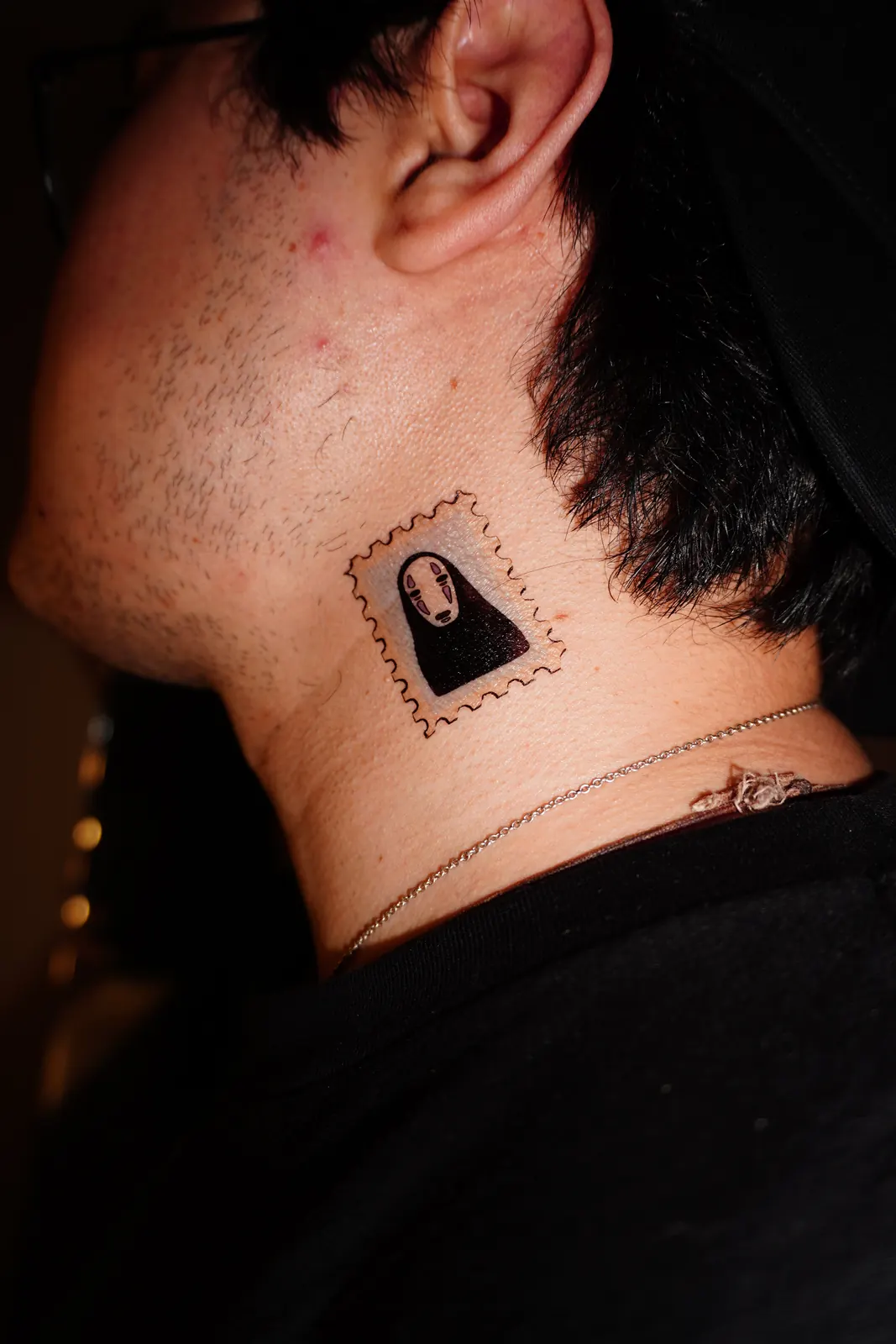 Postage-stamp temporary tattoo of No-Face (Spirited Away), applied on the neck