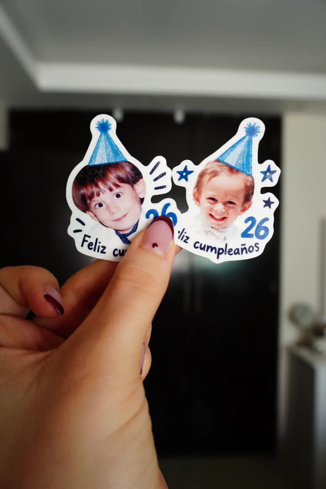 Two birthday temporary tattoos with childhood photos, held in a hand